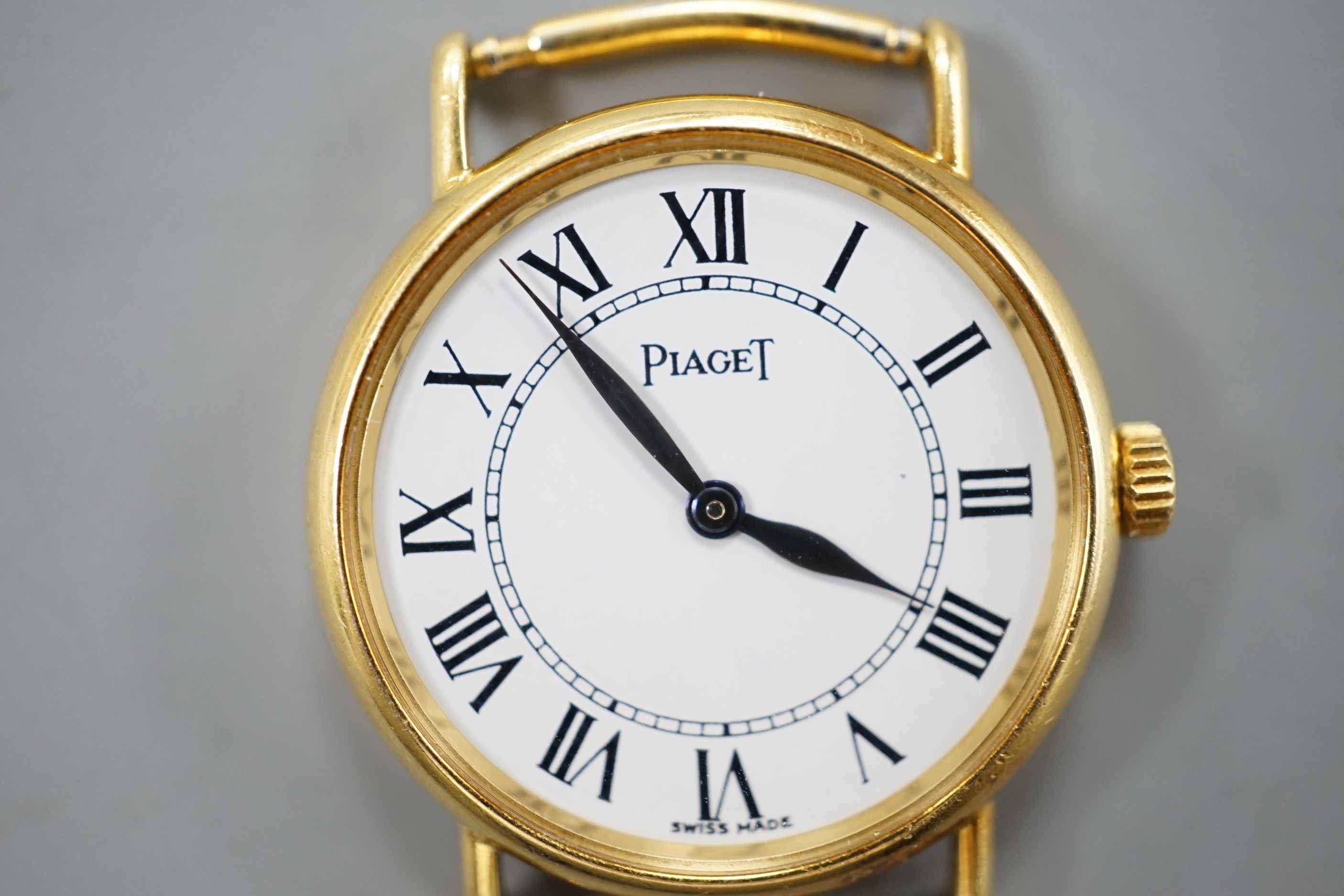 A lady's modern 18ct gold Piaget quartz wrist watch, with Roman dial, no strap, case diameter 23mm, gross weight 12.1 grams.